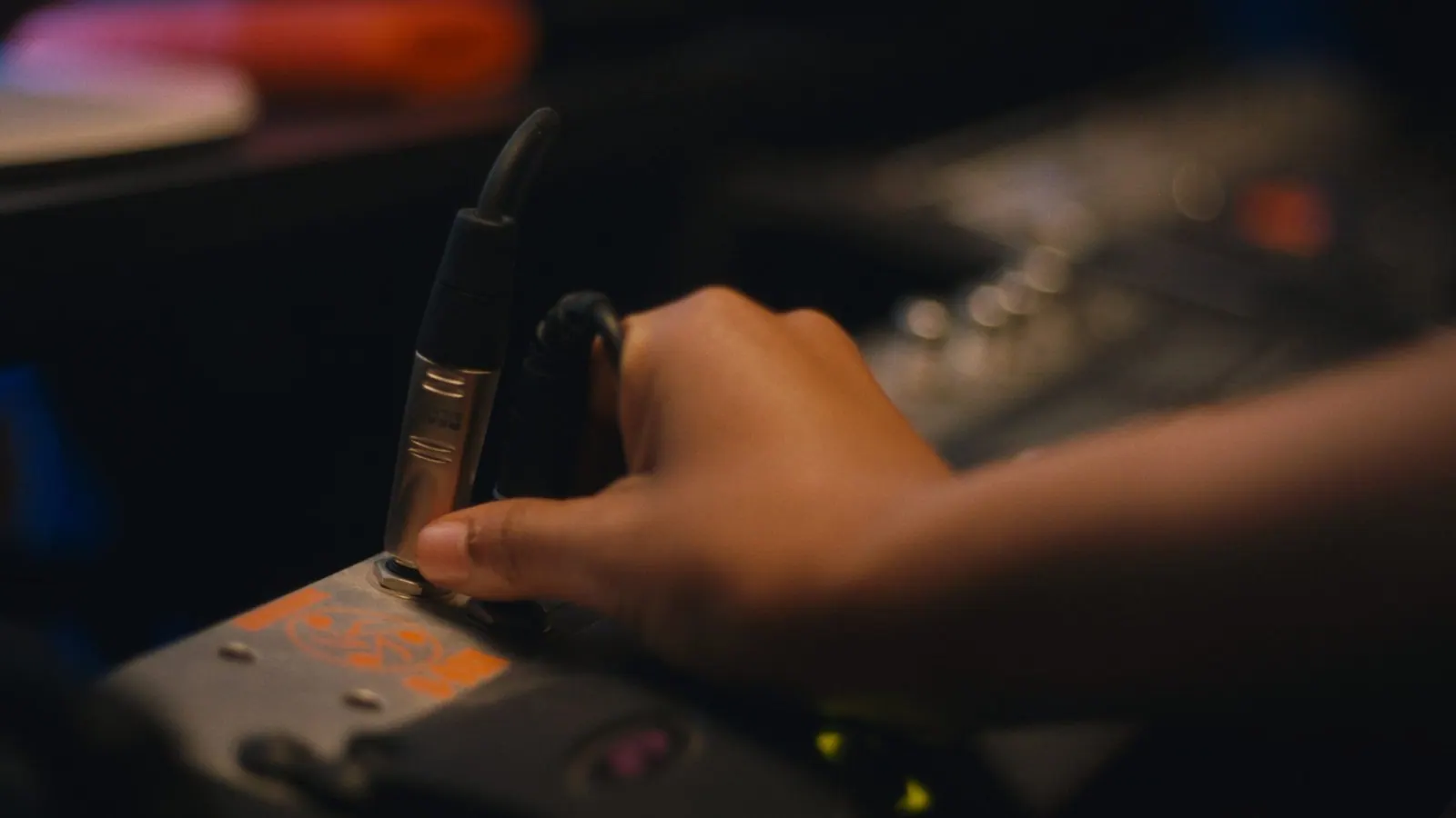 Close-up of a hand adjusting knobs on a console