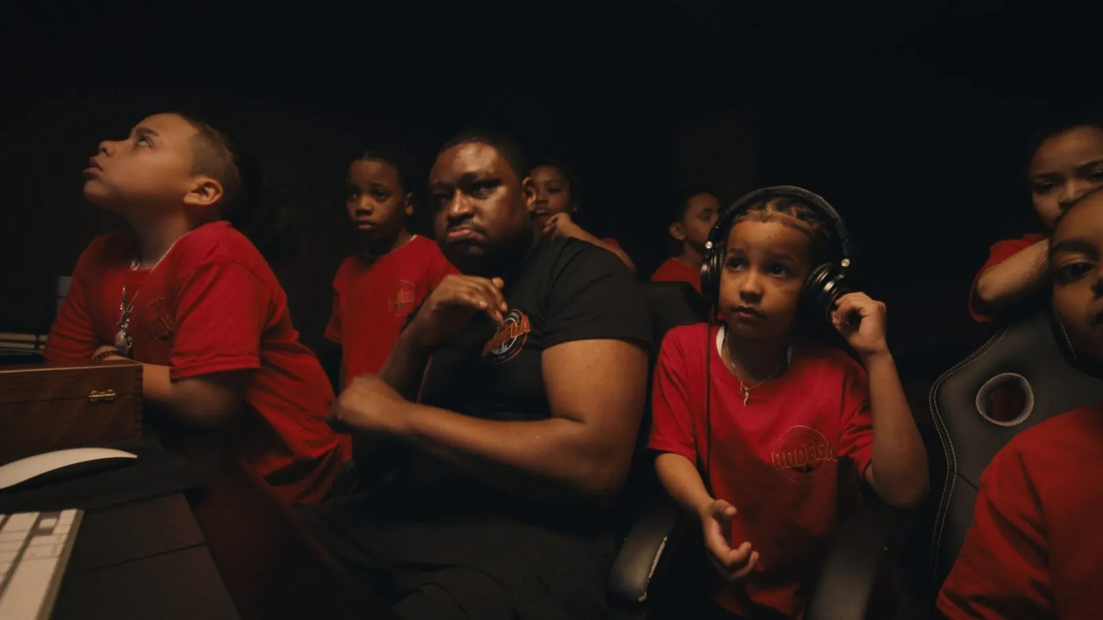 Students in headphones listen back with a mentor in the studio