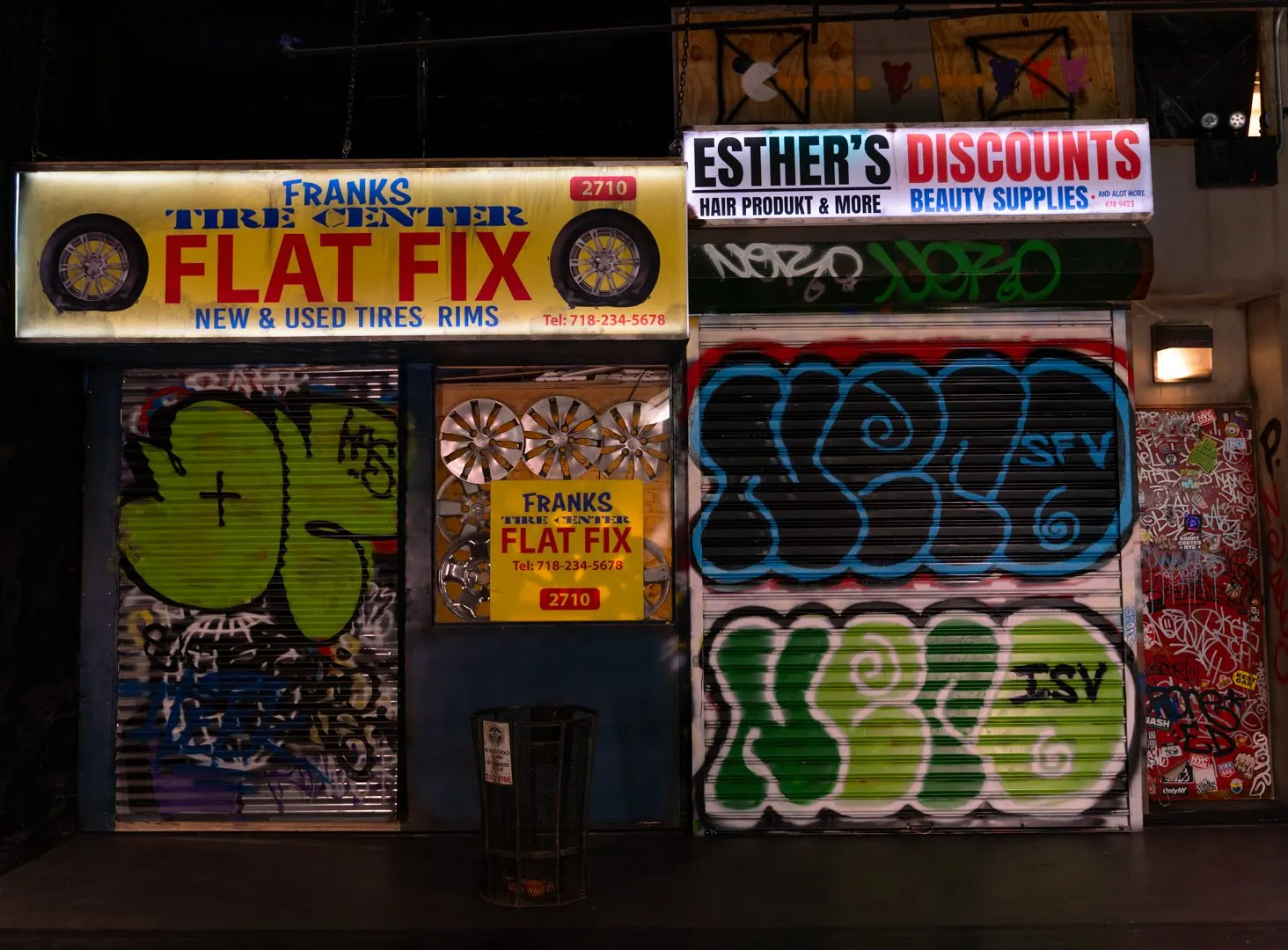 Flat Fix tire shop and Esther's Discounts storefronts with graffiti gates