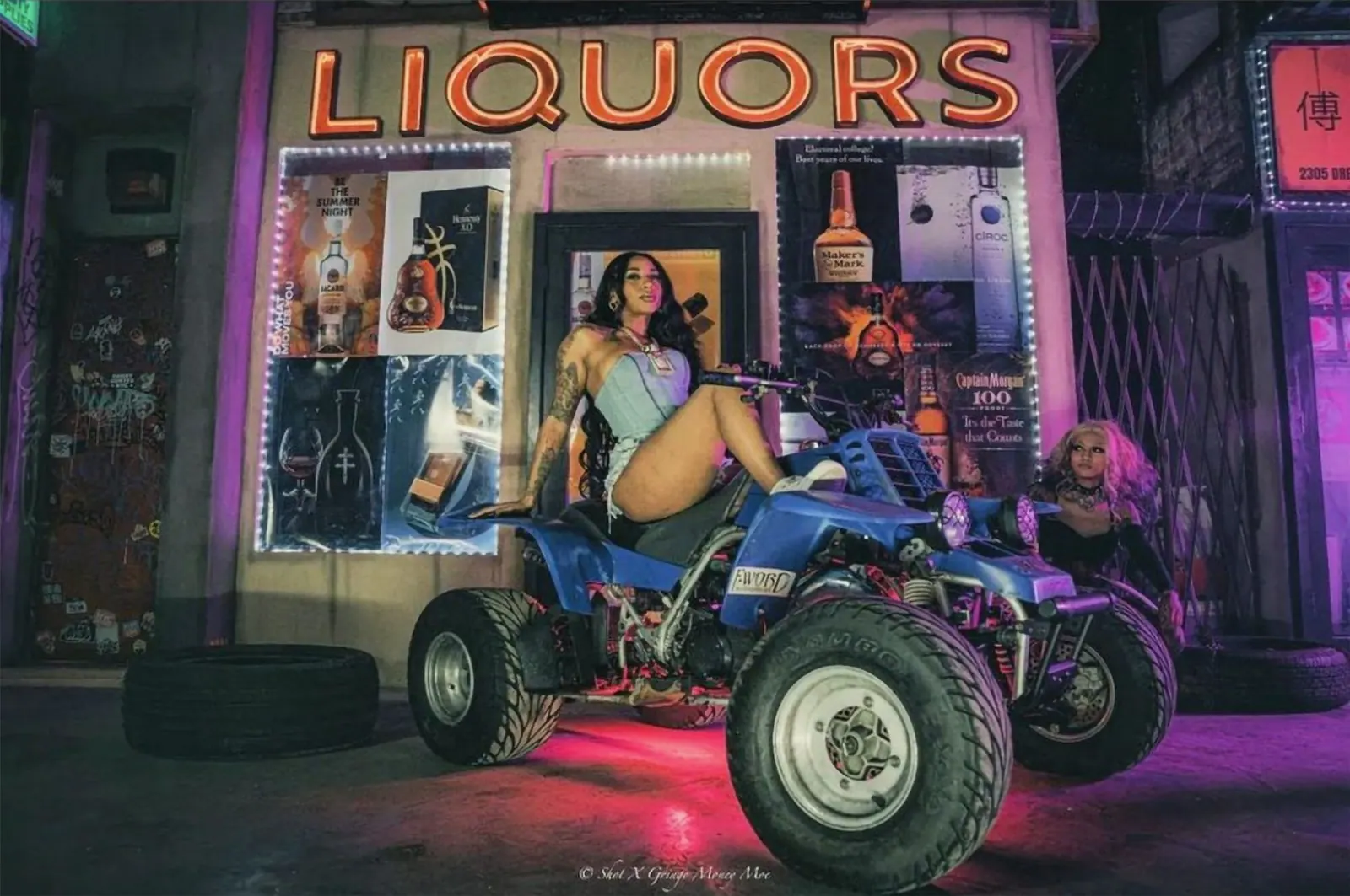 Model posing on an ATV in front of the Liquors storefront