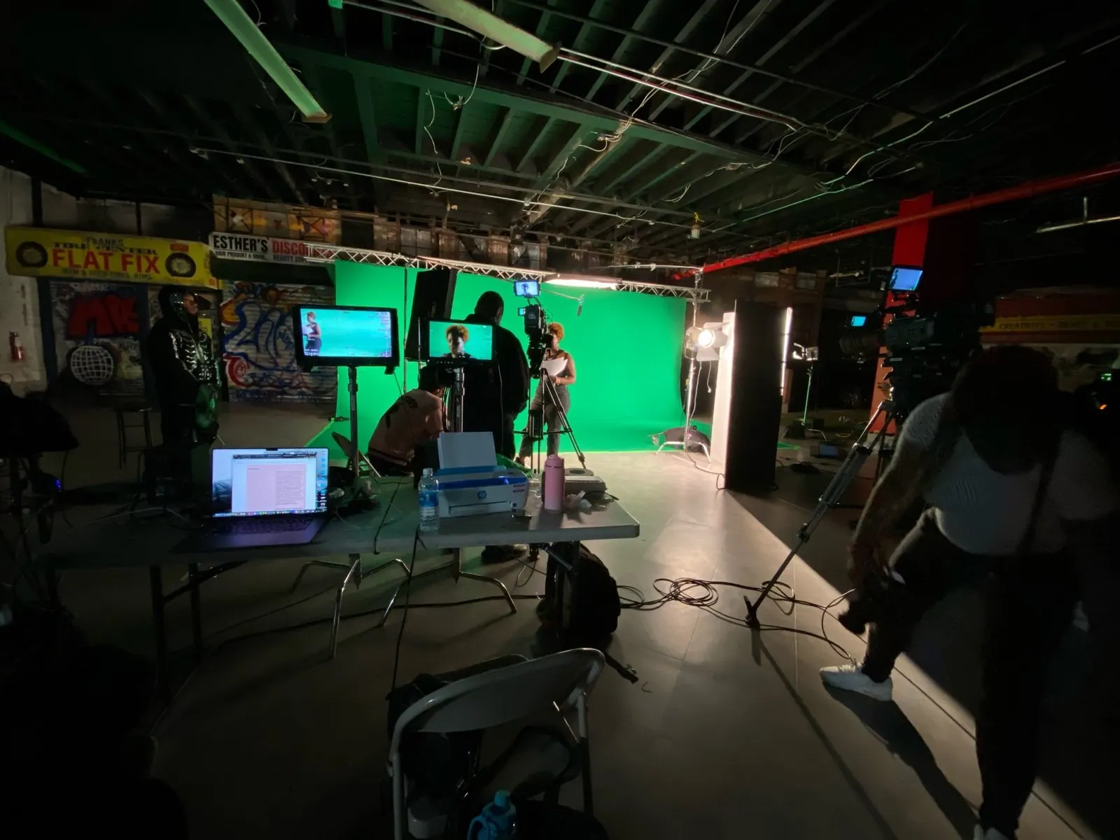 Wide view of the soundstage with a green screen and production gear